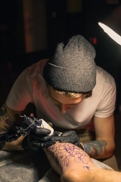 Focused tattoo artist applying ink