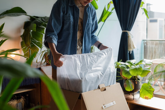 Opening a Box Indoors in a Cozy Space With Plants Around