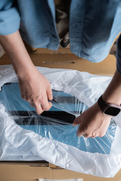 Anonymous man unwrapping his new suitcase
