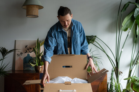 Man opening box with online order at home