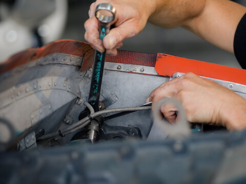 Working on an Engine With a Wrench in a Garage Setting
