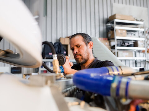 Mechanic is checking pressure in aircraft engine cooling system