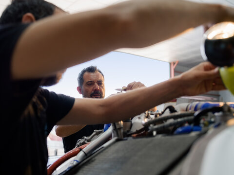 Busy mechanics are repairing airplane engine