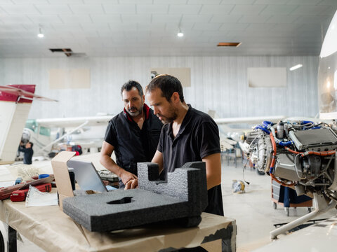 Mechanics using computer during aircraft inspection