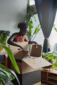 Excited woman opening box after delivery