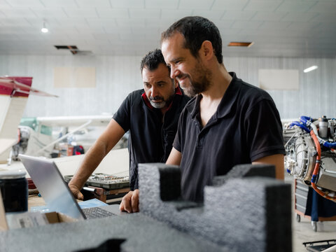 Mechanics using computer in hangar