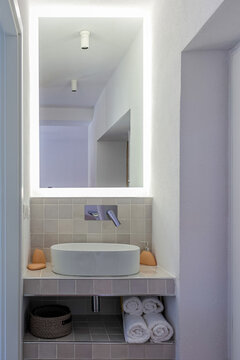 Backlit vanity glows in a narrow alcove