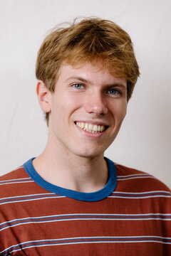 Cheerful young man looking at the camera with a confident expression.