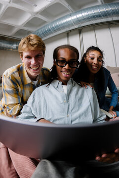 Modern team using a laptop to work in the living room of a coworking