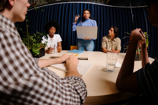 Freelance woman explaining a growth project during a team meeting.