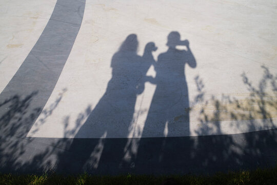 People take a photo while creating shadows on the ground
