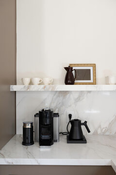 Kitchen Counter With Coffee Maker and Cups on the Shelf