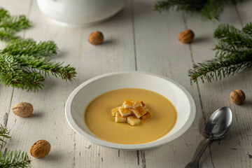 Fototapeta premium Creamy soup with croutons on rustic Christmas table