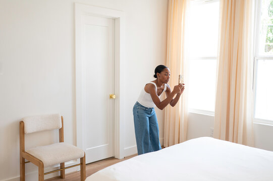 Person Takes a Picture in a Bright and Simple Bedroom
