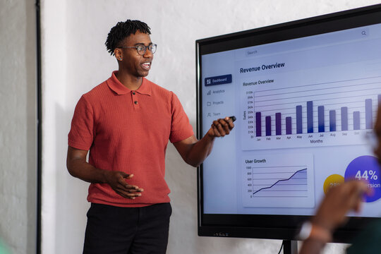 Business Presenter Showing Revenue Growth on Screen