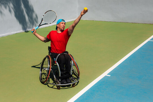 Wheelchair Tennis Player Serving Ball on Outdoor Court