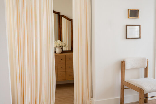 Interior View of a Room With Curtains, Chair, and Dresser