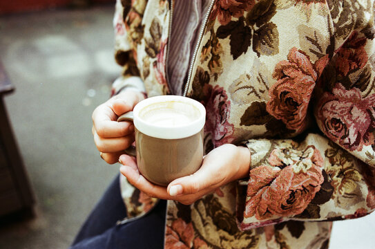 Woman holding cup of coffee outdoors