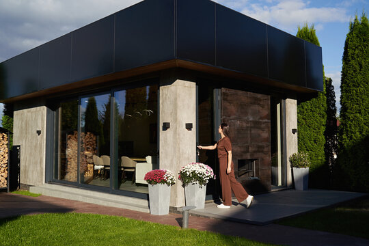 Woman opening door entering modern prefab ADU guest house