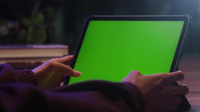 Tablet with green screen, close up of tablet pc chroma key mockup on table, hand touching blank green display, app template and copy space for presentation