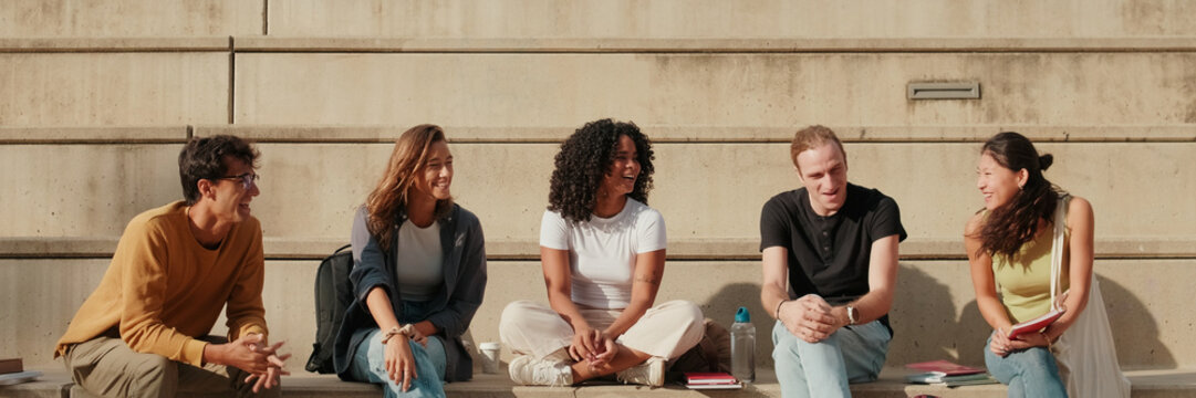 Friends Sit On Steps and Chat During Break