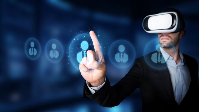 A business professional engages with virtual reality technology, interacting with digital user icons in a modern workspace, showcasing innovation and connectivity. Raster