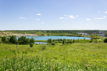 Beautiful green hill and blue lake showcasing northern nature during summer in the Far North of Russia. © PuzzleSoul