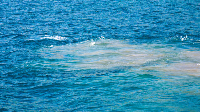 Fuel oil spill in ocean seawater from ship engine, marine pollution, toxic leakage from vessel motor into sea water.