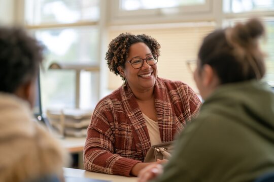 School principal with dark skin talking to a student, a supportive conversation in a warm office for education and mentorship