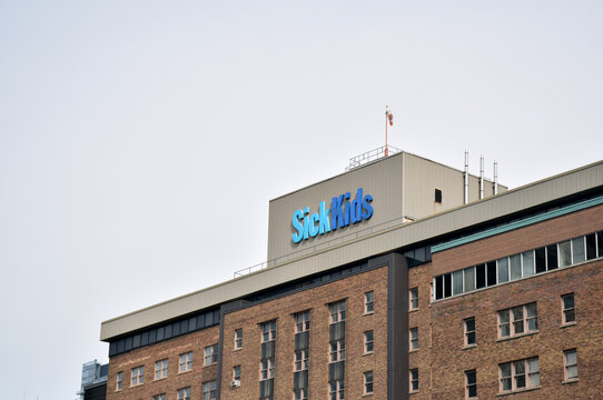 Low angle view of the brick SickKids hospital building exterior featuring a large blue SickKids sign on the roof, September 2026