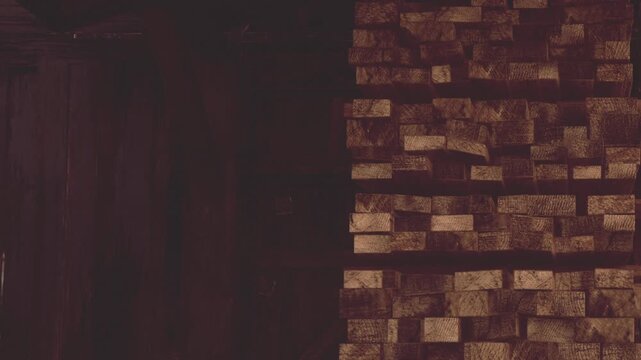 The warm glow of the wooden wall creates a cozy atmosphere, showcasing intricate textures and natural patterns in a charming indoor setting. The shadows add depth and warmth.