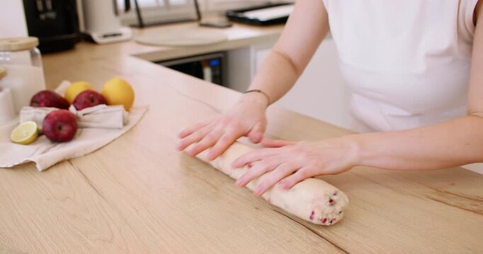 Cookies recipe. Baker work. Woman hand pressing shaping biscotti dough with cranberry on home kitchen table making healthy biscuit.