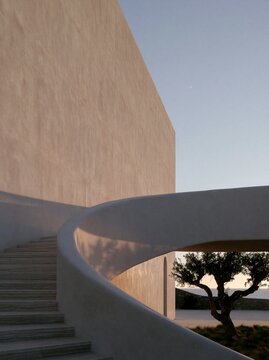 White courtyard stairway with a tree beneath a curved wall