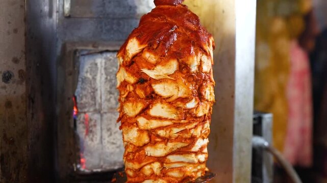 Shawarma a popular Middle Eastern street food made of thin slices of meat (traditionally lamb, mutton, or chicken) stacked in an inverted cone and roasted on a slow-turning vertical spit