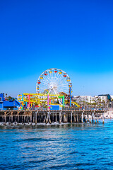 Fototapeta premium Santa Monica beachfront architecture under blue skies. White buildings along Santa Monica oceanfront. Santa Monica coastal buildings behind the beach. Beachfront cityscape near Santa Monica Pacific