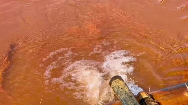 An old rusty tap from which an artificial lake is filled. Rusty sediment at the bottom of the lake. A pipe from which clean water flows. The faucet in the farmer's garden is open.