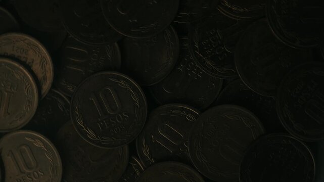 Close up view of saving money, Chilean peso coins, dim light background