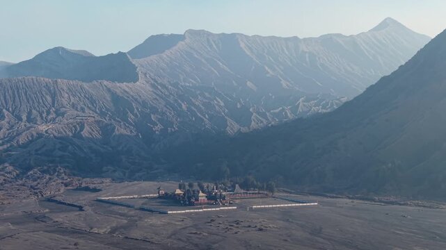 Distant mountains loom over rugged volcanic landscape at Pura Luhur Poten