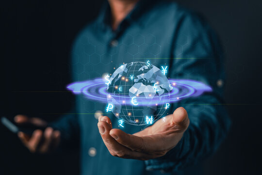 Businessman holding glowing digital globe with world currency exchange icons. Global economy, international trade, fintech money transfer, and online banking transaction technology concept.