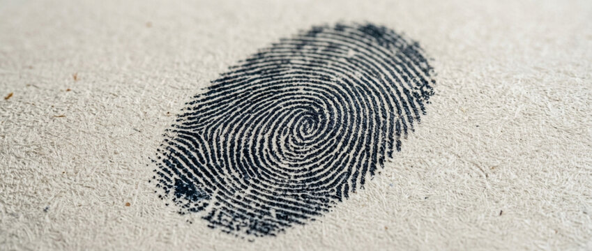 Detailed Macro Close up of a Black Fingerprint Impression on Textured Paper Surface