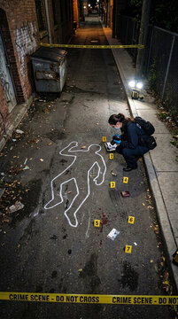 Crime Scene Investigation Detective Examining Chalk Outline and Evidence Markers in Grimy Alleyway