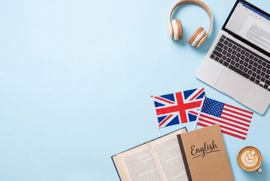 Learning English with flags and laptop on a blue table