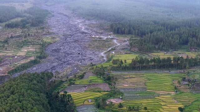 High angle perspective from the sky showing thick white fog floating over a solidified dry lava field at the base of Mount Semeru.