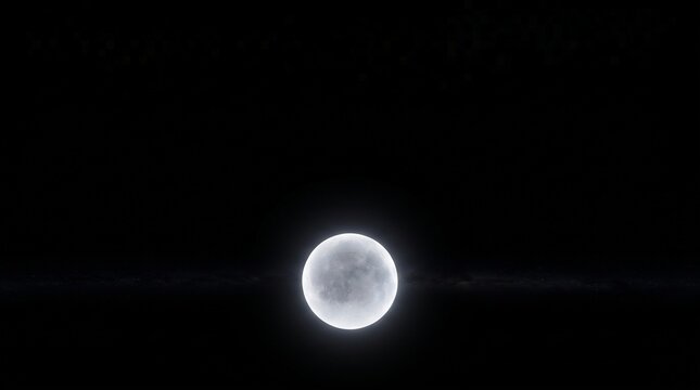 A luminous moon glowing softly against a deep black night sky, casting a faint glow on the surrounding darkness.
