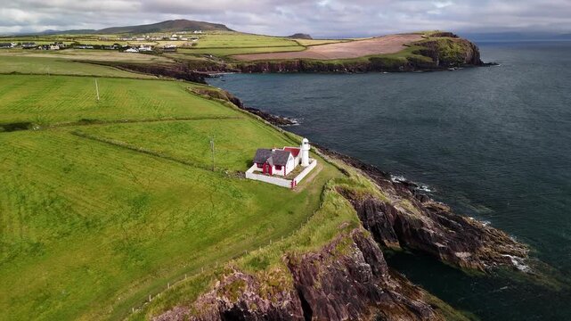 Dingle Lighthouse flyover with a wide view of the surrounding coastline