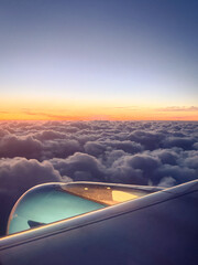 Fototapeta premium Airplane wing and engine against breathtaking sunset clouds and gradient sky, aerial travel and freedom concept