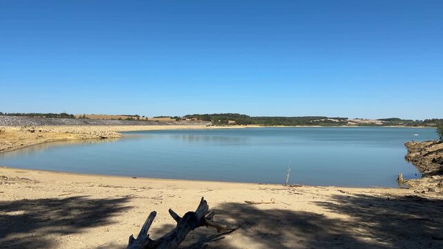 Ganguise Reservoir water level receding sandy shore dry driftwood resource