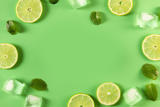 Fresh lime slices, mint leaves, and ice cubes frame