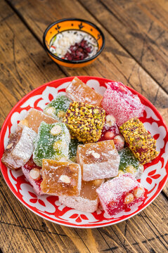 Mixed lokum candy cubesin eastern plate on wooden background. Handmade confectionery with modern rustic style.