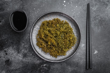 Fresh sea grapes also known as green caviar and sea caviar served in bowl on white background exotic Japanese umibudo seaweed © Mironov